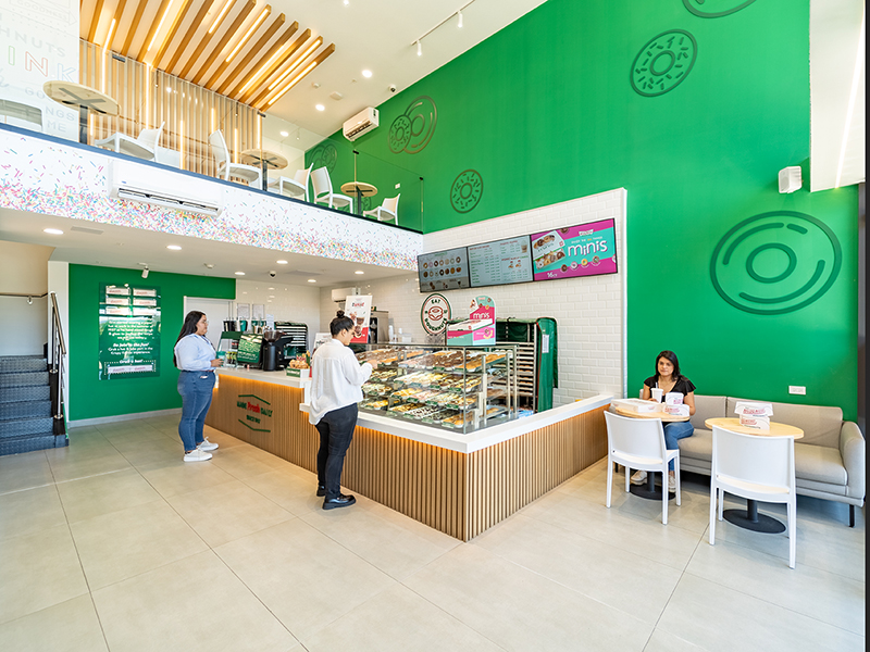Krispy Kreme - Open plan retail interior with double-height green feature wall - Contract Workplaces.jpg